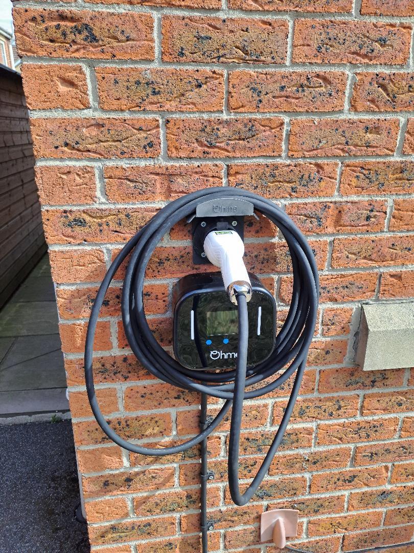 Ohme EV charger installed on brick wall