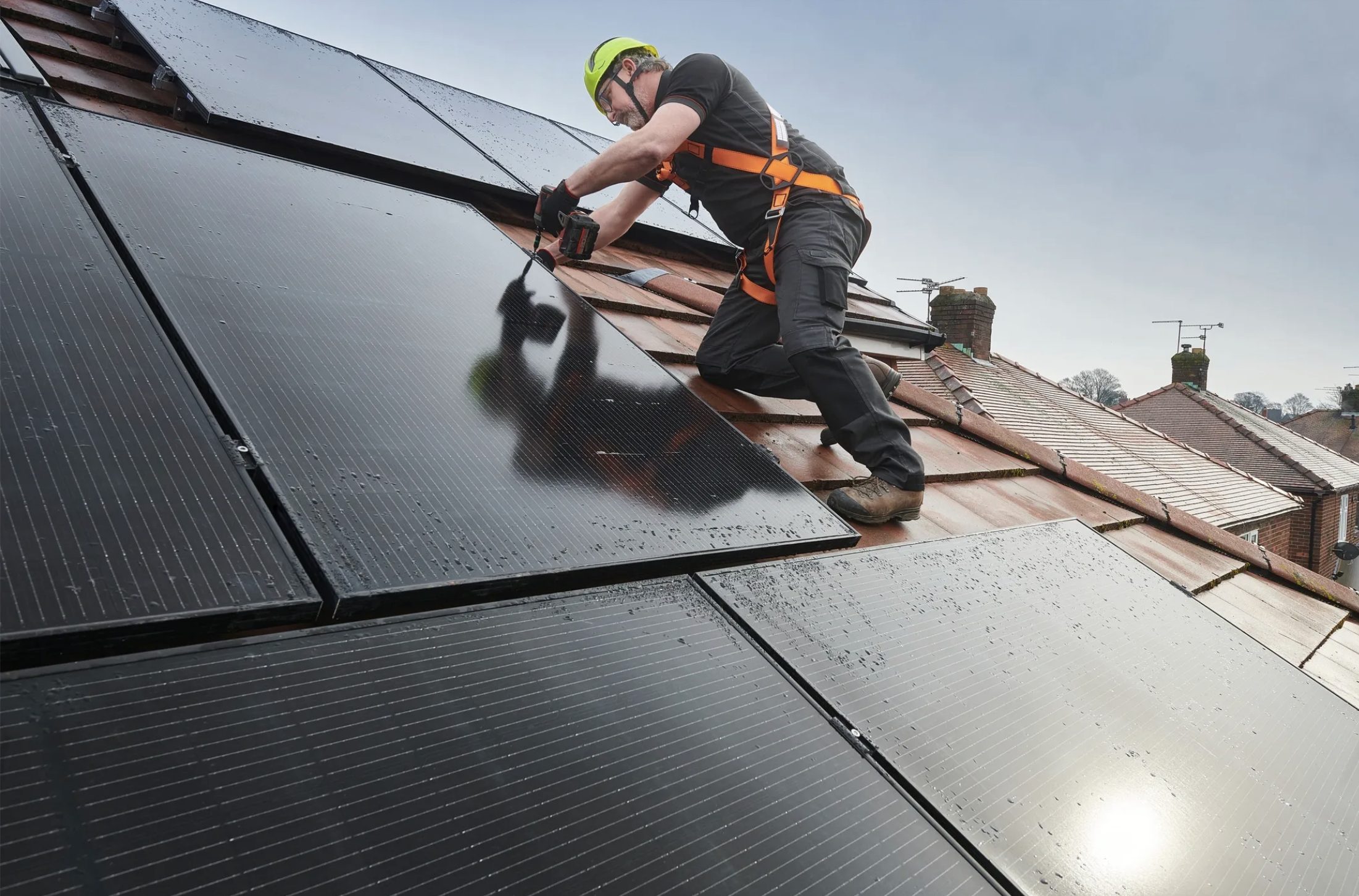 Installer fitting a solar panel on a roof